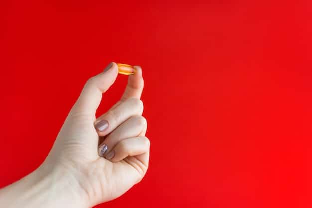 A close-up of a hand holding a vitamin D supplement capsule. The background is blurred, featuring a bottle of similar capsules and a soft, natural light. The focus is on the single capsule and the details of its composition, emphasizing the importance of supplementation for optimal health.
