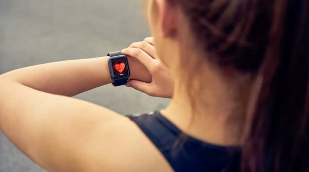 A close-up shot of a smartwatch displaying heart rate data, highlighting the role of wearable technology in personal health monitoring. Emphasize the sleek design and user-friendly interface of the device.