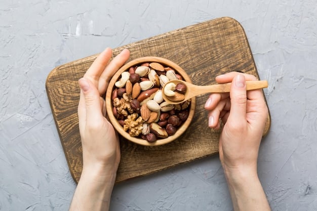A top-down view of a hand reaching for a bowl of mixed nuts among an array of unhealthy snacks, like candy bars, chips, and cookies, which are intentionally blurred in the background. The focus is sharp on the hand and the bowl of nuts, symbolizing a conscious choice for health.