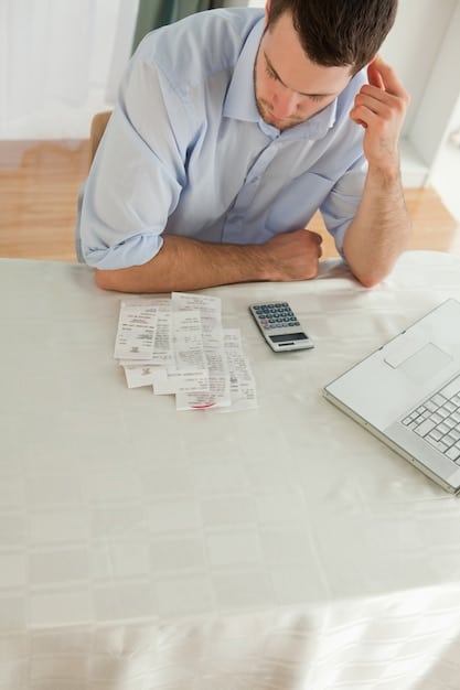 A person looking stressed while using a calculator with bills scattered around them, illustrating the direct impact of financial calculations on stress levels.