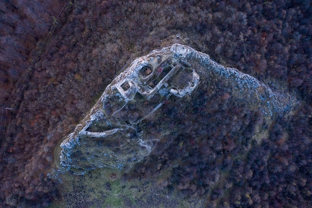 An aerial view of an e-waste recycling plant emitting smoke and fumes into the atmosphere. Several workers on the ground are not wearing adequate protective gear. The scene highlights air pollution issues related to e-waste recycling.