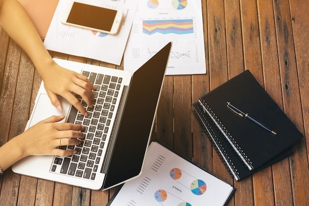 A photograph of a person working diligently on a laptop, surrounded by documents and graphs related to business planning and financial projections.
