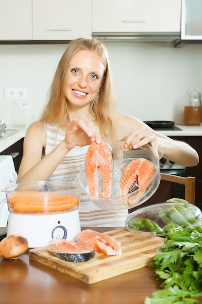 A person holding a plate of food rich in vitamin D, such as salmon, eggs, and fortified milk.